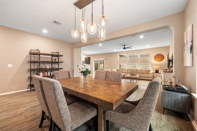 dining area featuring visible vents, light wood-style flooring, and a ceiling fan