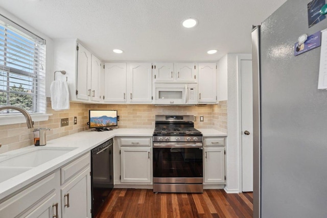 5217 Summerset Trl, Austin, TX 78749 - kitchen with appliances with stainless steel finishes, dark wood-style flooring, white cabinetry, tasteful backsplash, and a textured ceiling