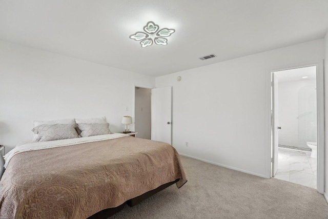 bedroom featuring visible vents, baseboards, light colored carpet, and ensuite bathroom