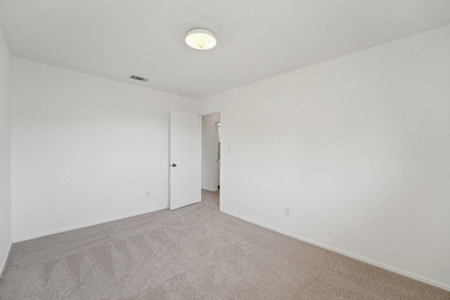 spare room with visible vents, baseboards, and carpet floors