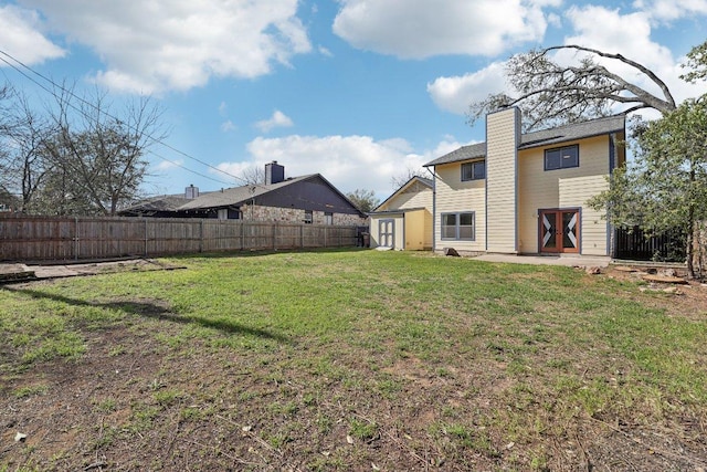 view of yard with a storage unit, a fenced backyard, and an outdoor structure