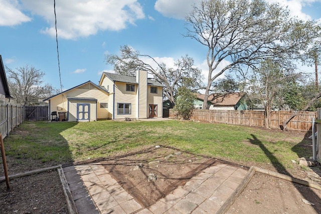 rear view of house featuring an outbuilding, a lawn, a chimney, and a fenced backyard