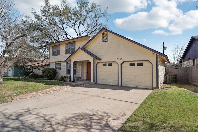 traditional-style house featuring fence, concrete driveway, a front yard, a garage, and stone siding