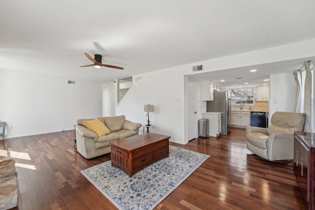 living area with dark wood finished floors, a ceiling fan, visible vents, and baseboards