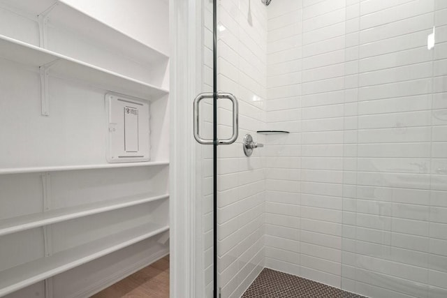 bathroom with a stall shower and wood finished floors