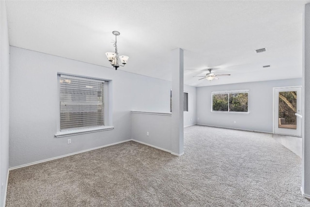 spare room with visible vents, ceiling fan with notable chandelier, baseboards, and carpet floors