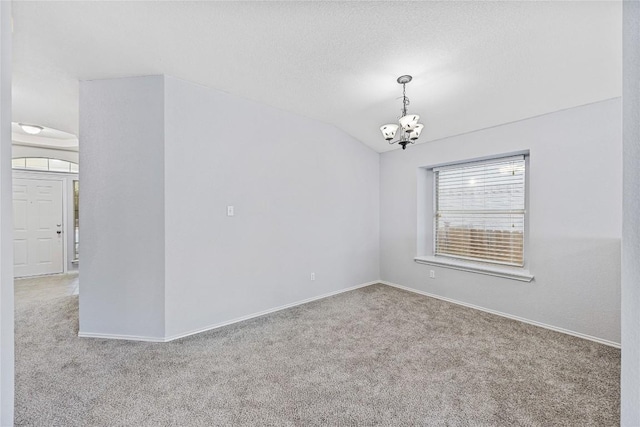 unfurnished room with an inviting chandelier, lofted ceiling, carpet, and baseboards