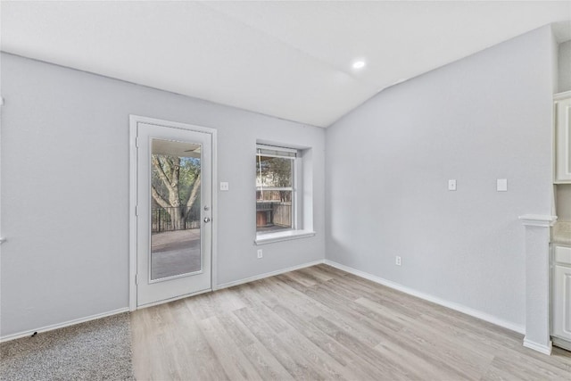 interior space with lofted ceiling, light wood-style floors, and baseboards