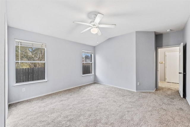 carpeted empty room featuring ceiling fan, baseboards, and lofted ceiling