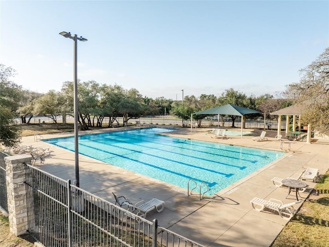 pool with a patio and fence