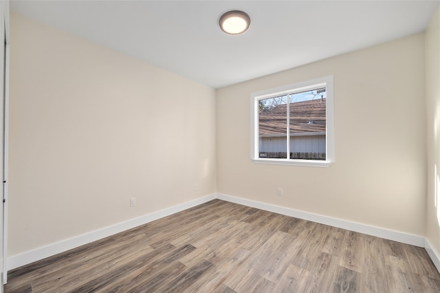 empty room featuring baseboards and wood finished floors