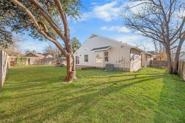 rear view of house featuring cooling unit, a fenced backyard, and a yard