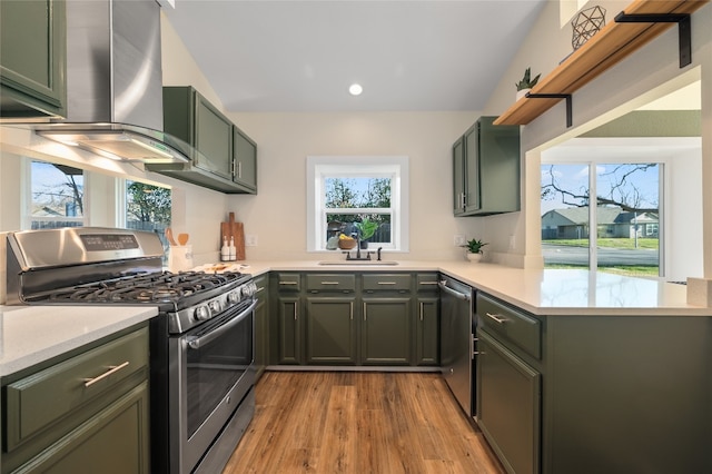 kitchen with appliances with stainless steel finishes, light countertops, green cabinets, and a sink