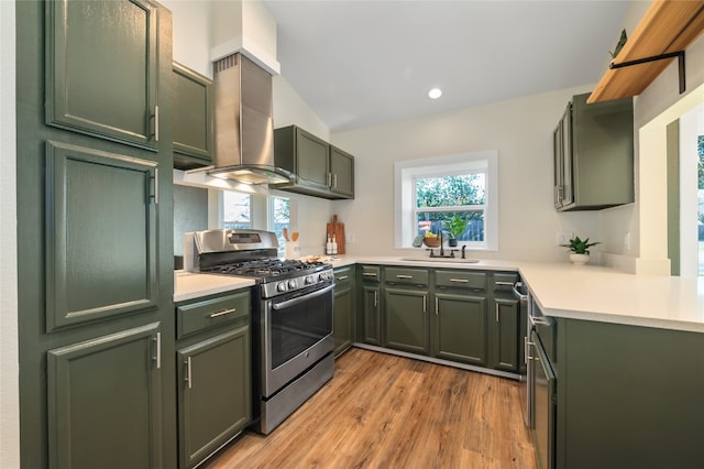 kitchen with a sink, gas range, light countertops, and green cabinetry