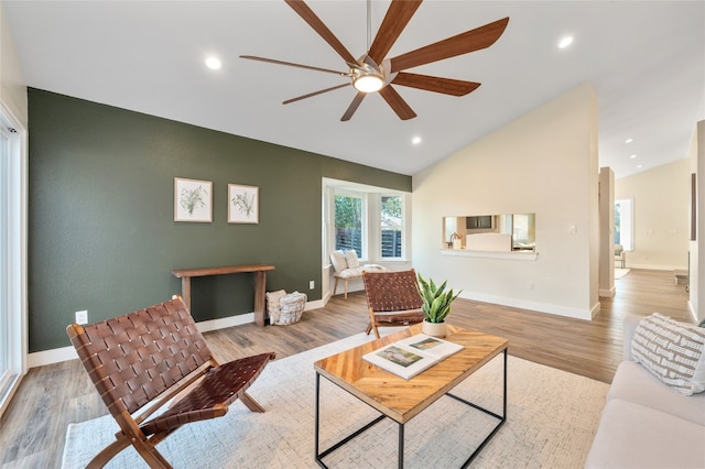 living room with recessed lighting, baseboards, lofted ceiling, and wood finished floors