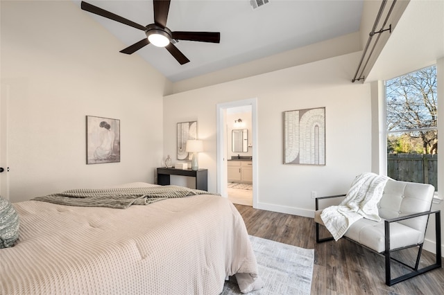 bedroom featuring visible vents, ensuite bathroom, wood finished floors, baseboards, and lofted ceiling