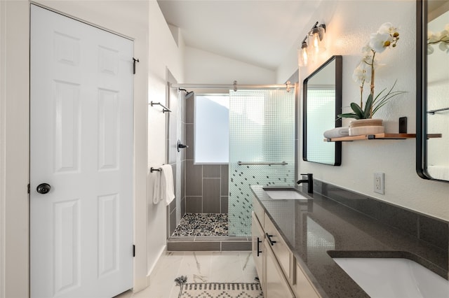 full bath featuring a shower stall, double vanity, lofted ceiling, and a sink