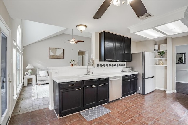 kitchen featuring visible vents, a sink, stainless steel dishwasher, freestanding refrigerator, and light countertops