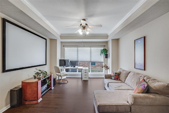 interior space featuring a ceiling fan, a raised ceiling, dark wood-type flooring, and crown molding