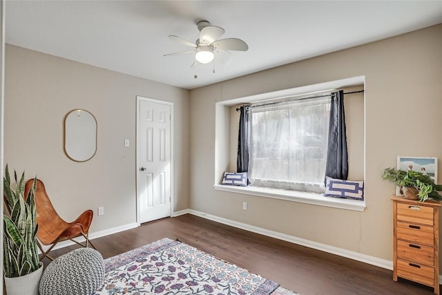 sitting room with ceiling fan, baseboards, and wood finished floors