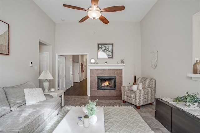 living area featuring a fireplace and ceiling fan