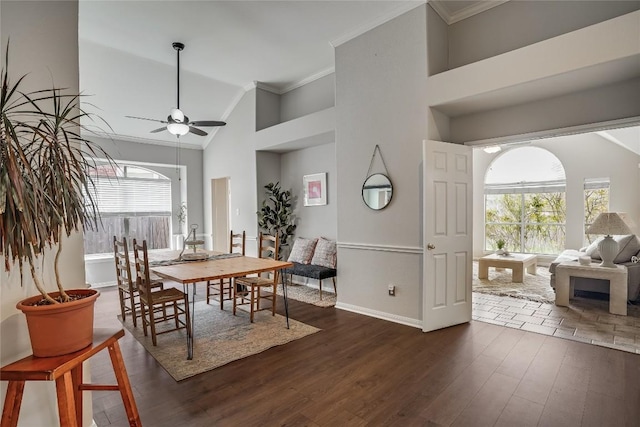 dining room featuring a ceiling fan, baseboards, high vaulted ceiling, dark wood-style flooring, and crown molding