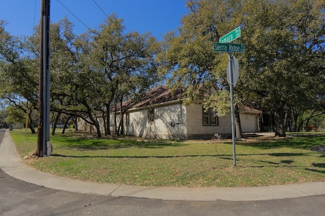 view of property exterior featuring a lawn and an attached garage