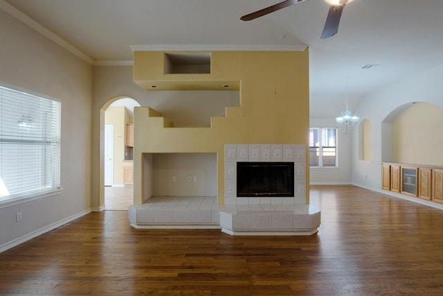 unfurnished living room featuring crown molding, a fireplace, dark wood-type flooring, and baseboards