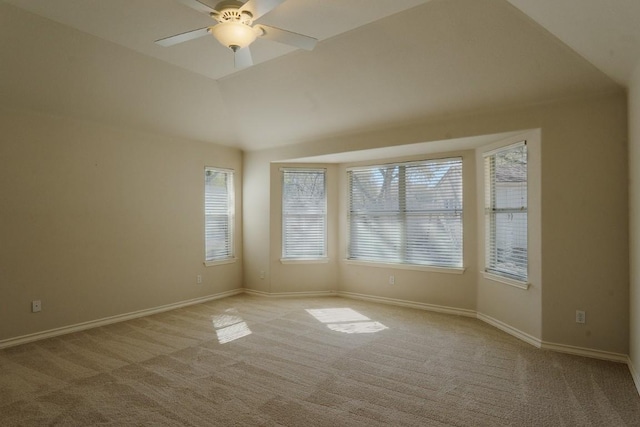 unfurnished room featuring a ceiling fan, vaulted ceiling, light colored carpet, and baseboards