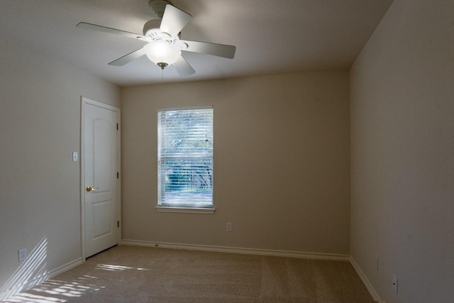 carpeted spare room with baseboards and ceiling fan