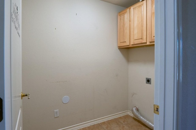 clothes washing area with light tile patterned floors, cabinet space, baseboards, and electric dryer hookup