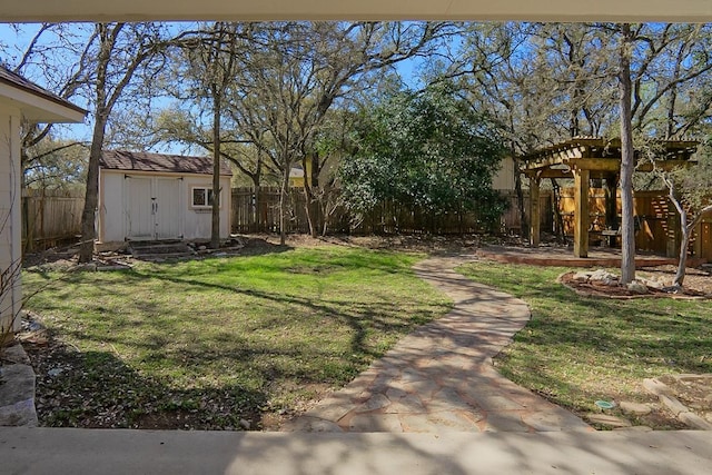 view of yard with a shed, an outdoor structure, a fenced backyard, and a pergola