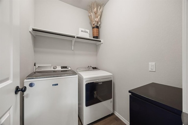 laundry room with dark wood finished floors, laundry area, and washing machine and dryer