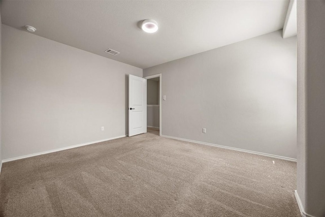 spare room featuring visible vents, baseboards, and carpet