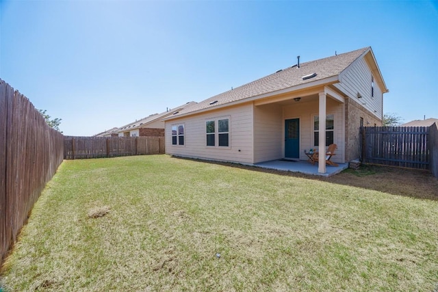 rear view of house with a patio area, a fenced backyard, and a lawn