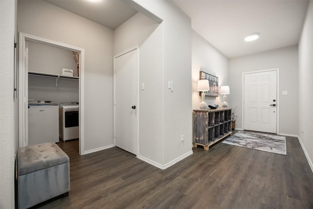 foyer entrance with dark wood-type flooring, baseboards, and washer and clothes dryer