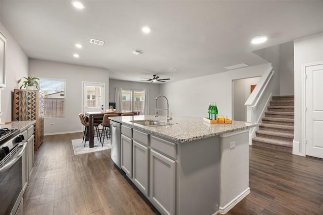 kitchen with visible vents, gray cabinetry, a sink, dark wood-type flooring, and appliances with stainless steel finishes