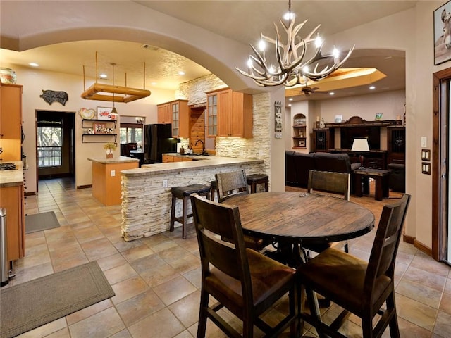 dining space with visible vents, baseboards, a chandelier, recessed lighting, and arched walkways