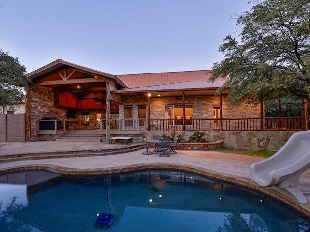 outdoor pool with a patio and a water slide