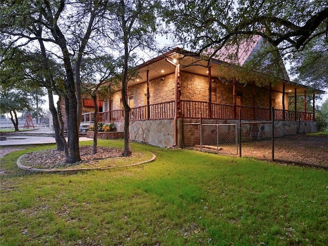 view of side of property featuring a yard and stone siding