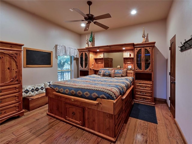 bedroom with recessed lighting, light wood-style floors, and baseboards