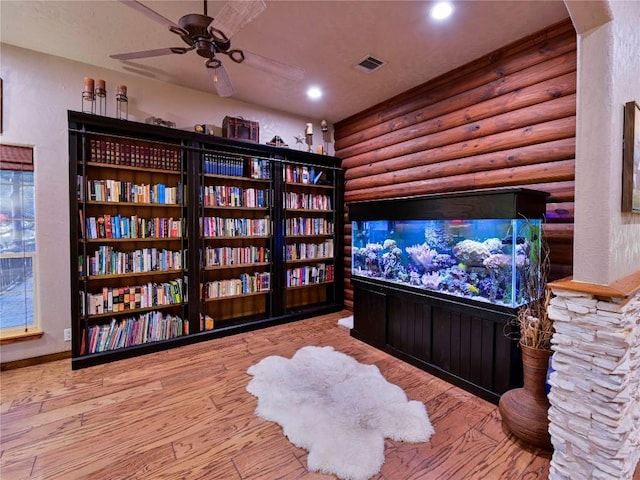 sitting room featuring rustic walls, a ceiling fan, wood finished floors, and recessed lighting