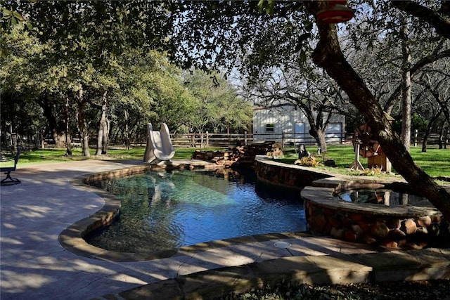 pool with a water slide and fence