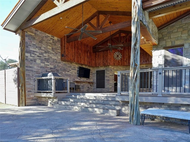 doorway to property featuring a patio area, stone siding, and ceiling fan