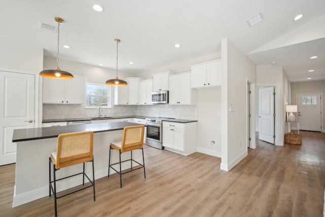 103 Manana Ct, Bastrop, TX 78602 - kitchen featuring appliances with stainless steel finishes, plenty of natural light, tasteful backsplash, and recessed lighting