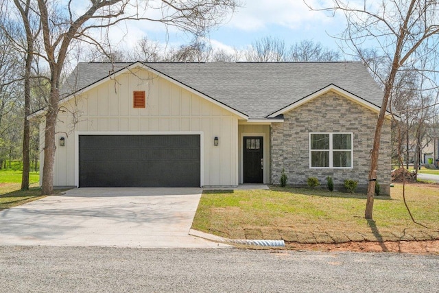 view of front facade featuring driveway, a front lawn, stone siding, an attached garage, and a shingled roof