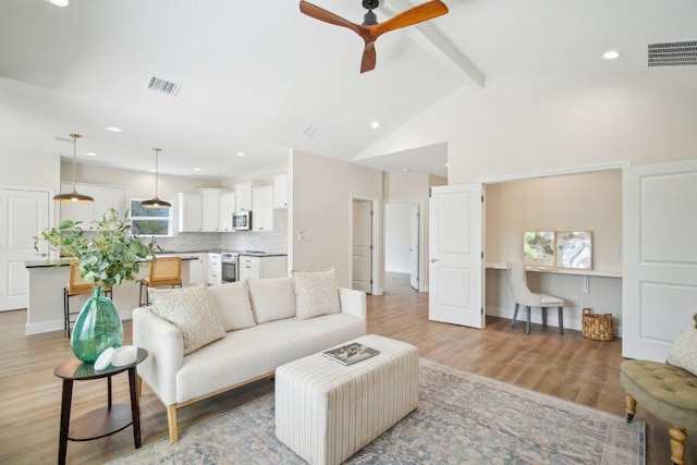 living room with vaulted ceiling with beams, a ceiling fan, visible vents, and light wood-type flooring