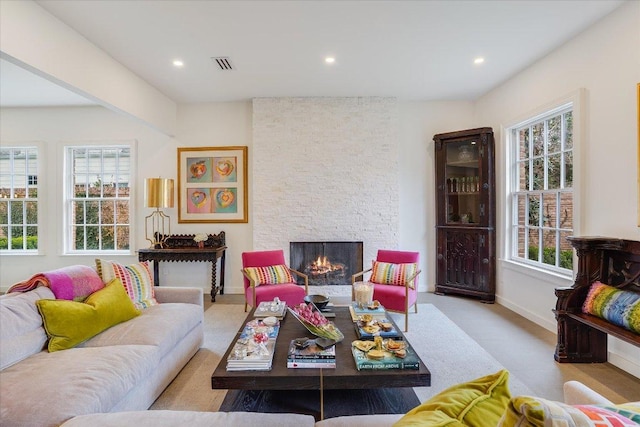 living room featuring a wealth of natural light, visible vents, recessed lighting, and a fireplace