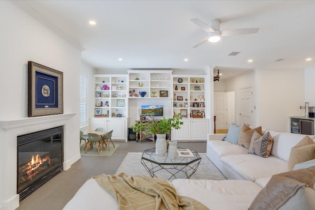 tiled living room with a glass covered fireplace, recessed lighting, visible vents, and ornamental molding