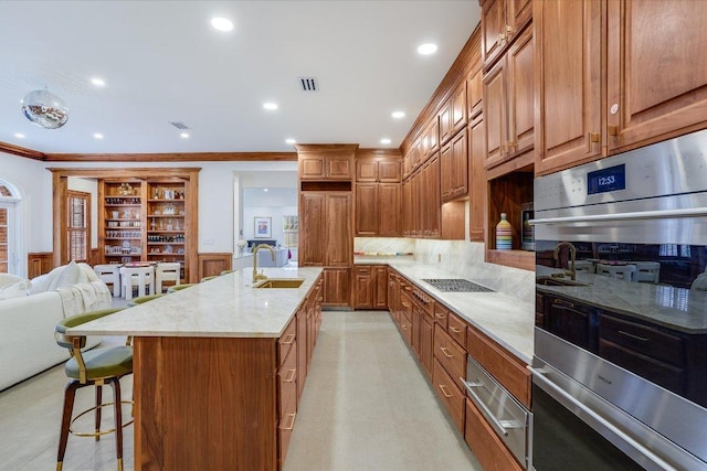 kitchen with a warming drawer, a breakfast bar, a sink, stainless steel double oven, and crown molding